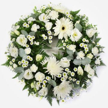 wreath-featuring-white-chrysanthemum-blooms-white-gerbera-white-lisianthus-white-spray-carnations-on-a-grey-background-1