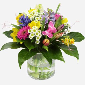 a-colourful-spring-bouquet-with-daffodils-gerberas-and-a-decorative-butterfly-in-a-glass-vase-1