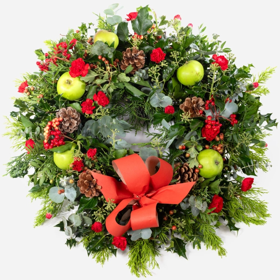 Traditional christmas wreath with festive foliage pinecones apples and a red bow traditional christmas wreath with festive foliage pinecones apples and a red bow